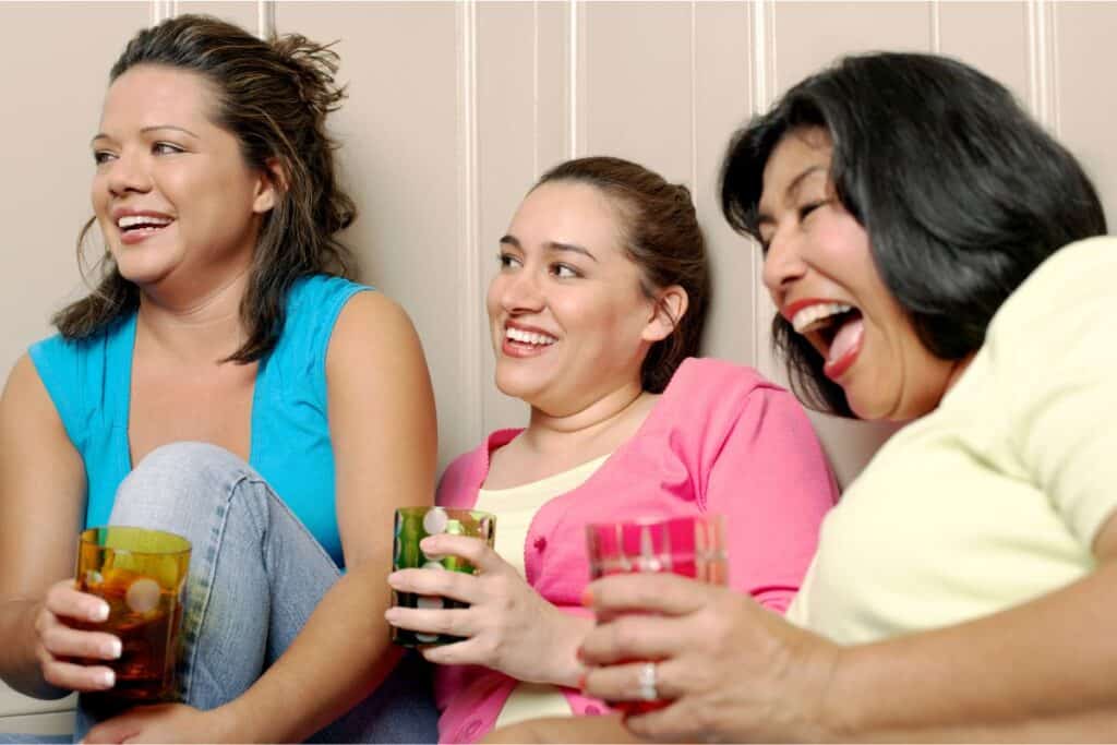 three women laughing while playing a party game