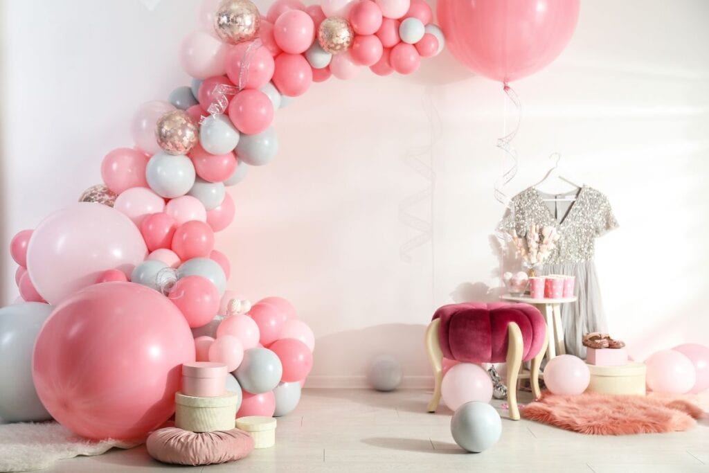 Balloon garland and other props being used as a focal point to decorate a large space for a party.