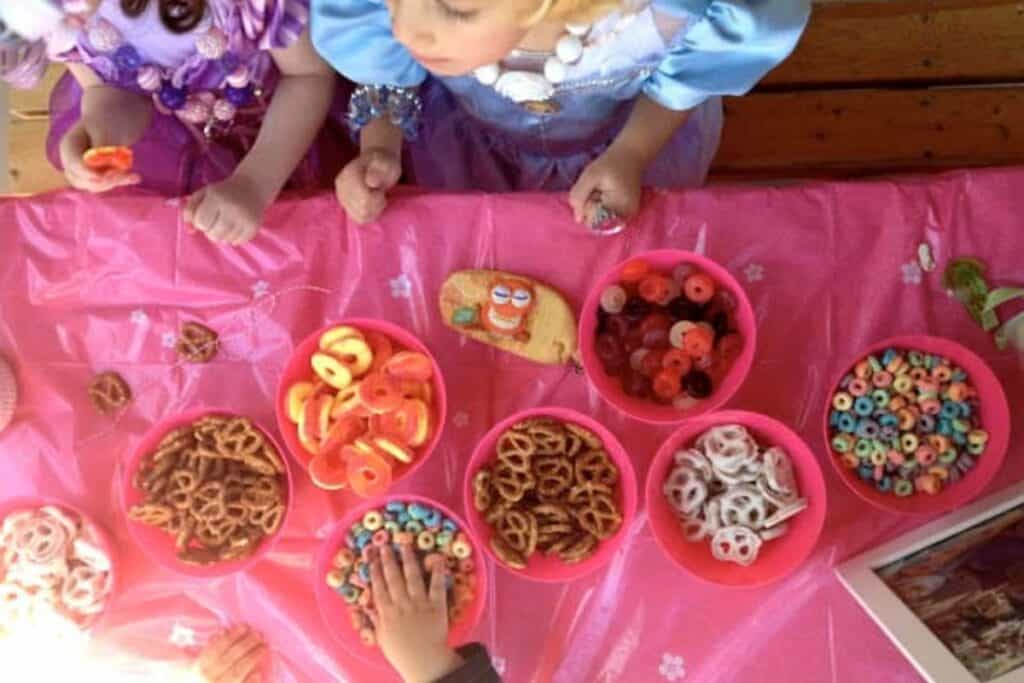 Girls making candy necklaces with various treats that can be strung on string and that kids really enjoy.