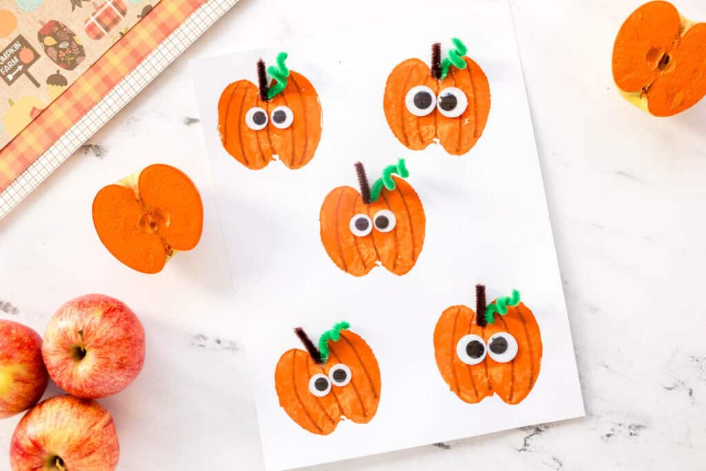 Darling Halloween craft using an apple stamp to make the cutest little pumpkins.