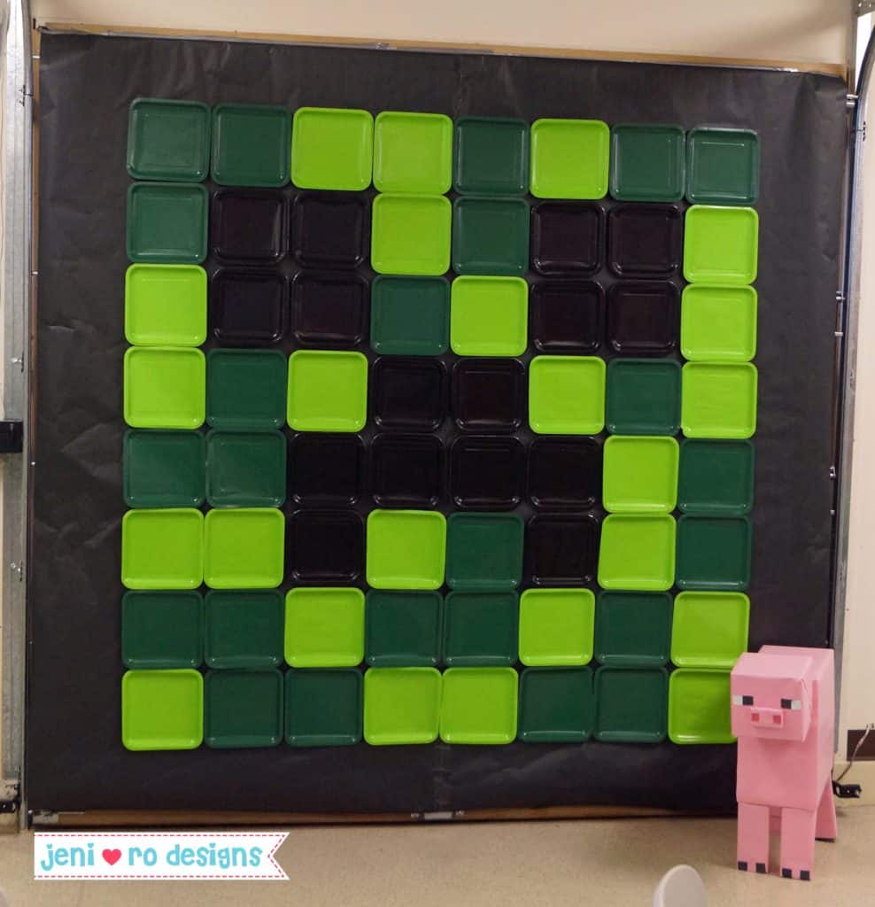 Creeper face backdrop made from square paper plates. This is a great Minecraft birthday party decoration.