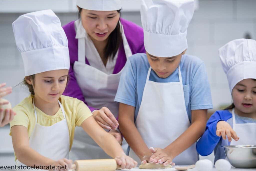 Children excitedly cooking at a birthday party, participating in a hands-on cooking activity. They are working together in the kitchen, mixing ingredients and preparing their own dishes, with a chef in the background showing them cooking techniques.