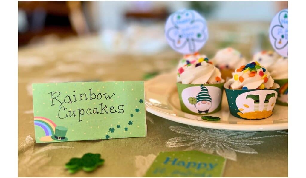 closeup of st. patrick's day mini cupcakes and food label that says rainbow cupcakes