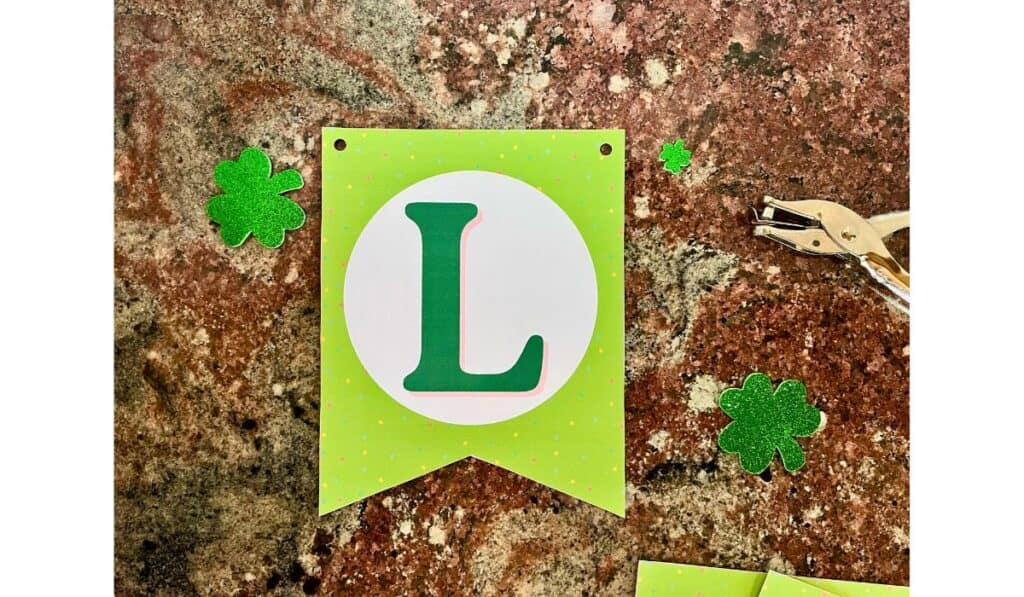 one piece of the st. patrick's day banner showing where to hole punch the holes for the ribbon