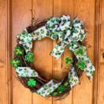 DIY St. Patrick's Day wreath made with green and white ribbon and other small clover decor