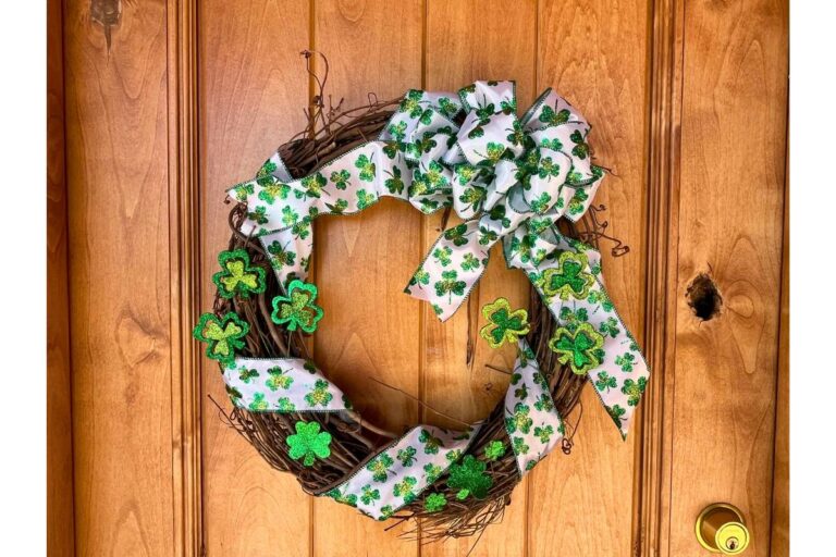 DIY St. Patrick's Day wreath made with green and white ribbon and other small clover decor