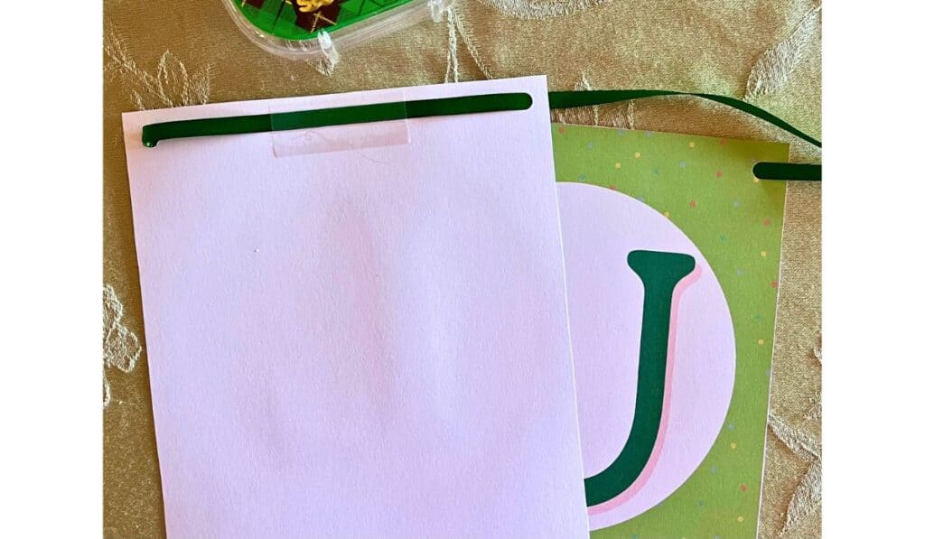 the back of the st. patrick's day banner showing how to tape it in place on the ribbon