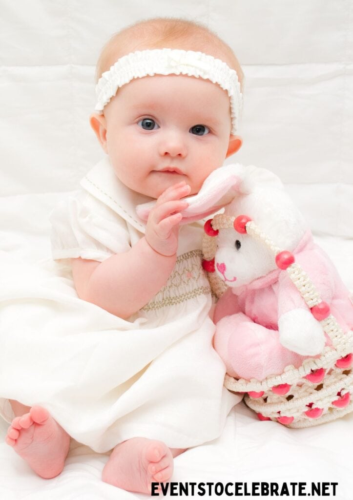 Baby holding an Easter basket with a plush toy inside the Easter basket.